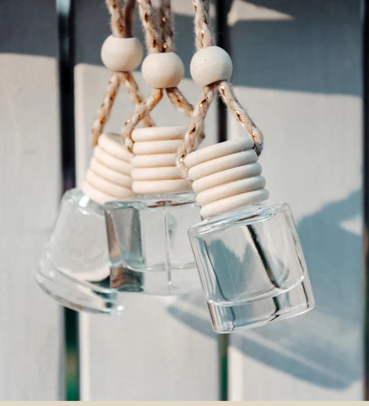 Decorative hanging with glass bottles and wooden beads against a neutral background