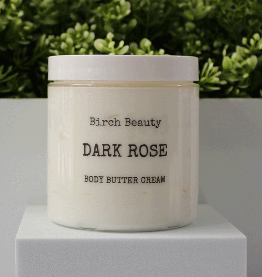Jar of 'Dark Rose' body butter cream with 'Birch Beauty' branding on a light surface with greenery in the background.