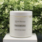 Jar of 'Cashmere' body butter cream with 'Birch Beauty' branding on a light surface with greenery in the background. Handmade in Rhode Island. Made with limited ingredients.