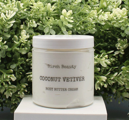 Jar of 'Coconut Vetiver' body butter cream with 'Birch Beauty' branding on a light surface with greenery in the background. Handmade in Rhode Island. Made with limited ingredients.