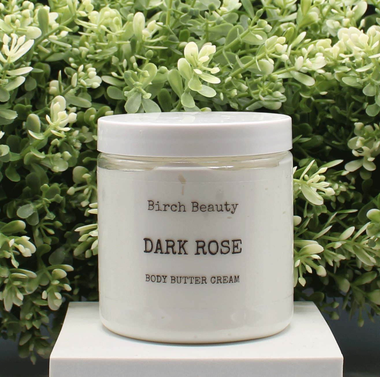 Jar of 'Dark Rose' body butter cream with 'Birch Beauty' branding on a light surface with greenery in the background. Handmade in Rhode Island. Made with limited ingredients.