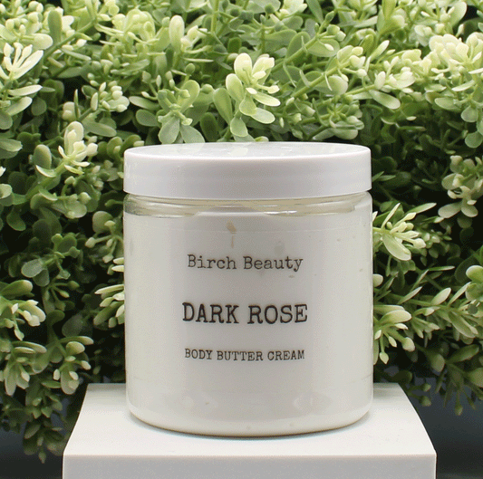 Jar of 'Dark Rose' body butter cream with 'Birch Beauty' branding on a light surface with greenery in the background. Handmade in Rhode Island. Made with limited ingredients.