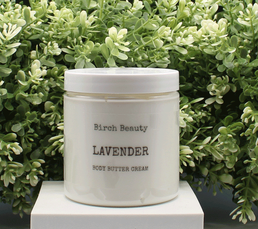Jar of 'Lavender' body butter cream with 'Birch Beauty' branding on a light surface with greenery in the background. Handmade in Rhode Island. Made with limited ingredients.
