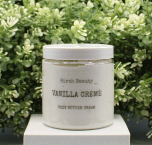 Jar of 'Vanilla Creme' body butter cream with 'Birch Beauty' branding on a light surface with greenery in the background. Handmade in Rhode Island. Made with limited ingredients.